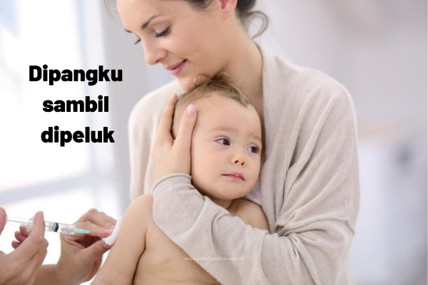 Divaksin sambil memeluk anak